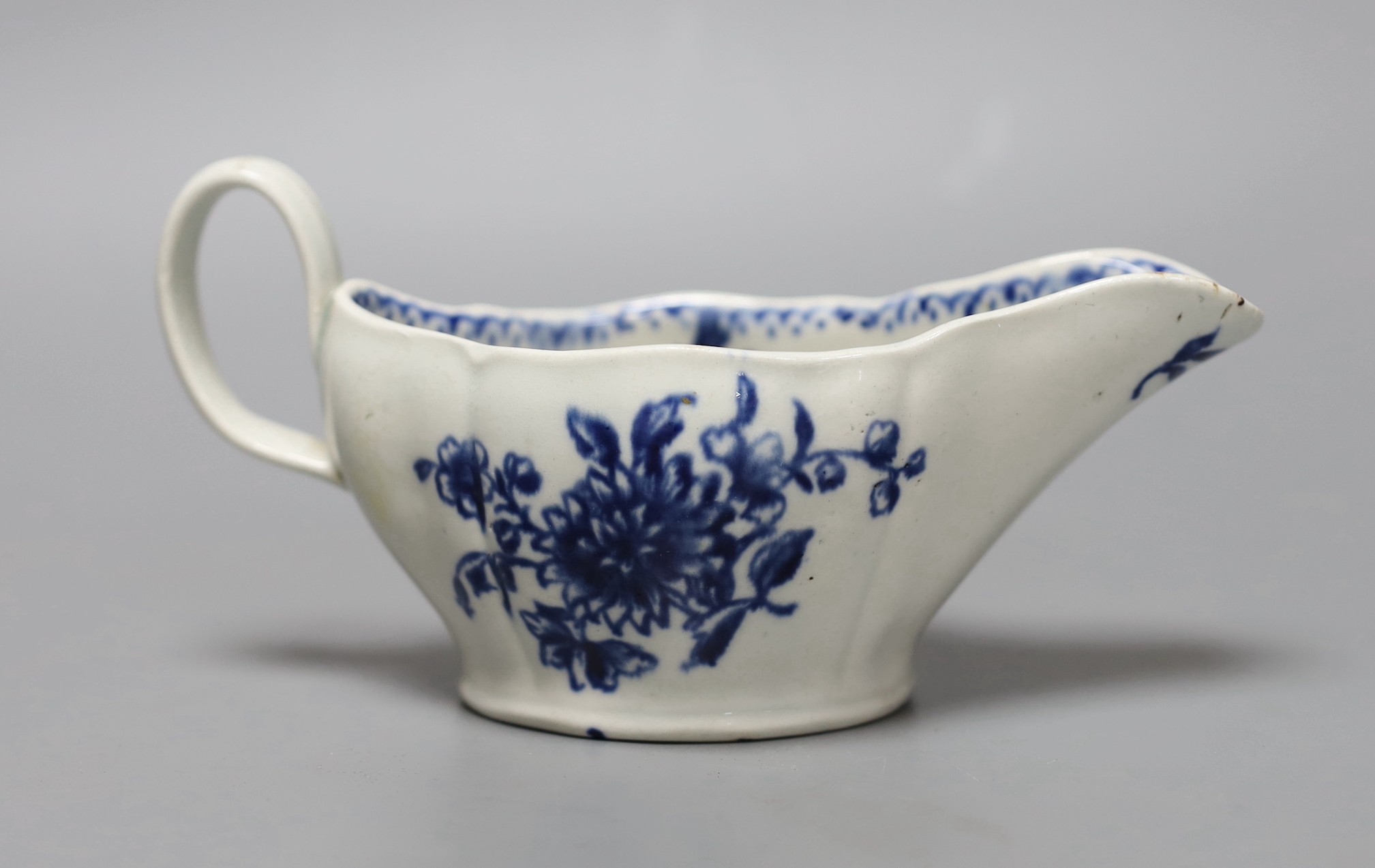 A Liverpool sauceboat decorated in blue underglaze flowers, the interior with further flowers and a dot and loop border, 16cm long